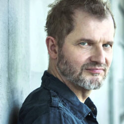 A profile photograph of composer Reinhold Heil